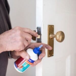 a-handyman-attending-to-door-lock-repairs-in-a-bright-white-bedroom-during-a-home-do-it-yourself-home